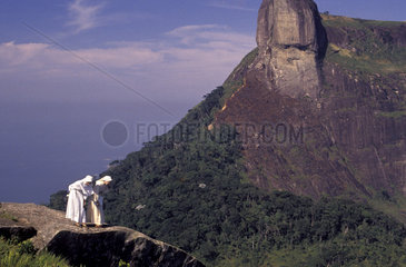 Nuns enjoying sightseeing in the mountains of Rio de Janeiro city  Brazil. Sister  sisters  member of a religious order  looking down  religion  Catholicism  Catholic  fun  recreation  amusement  diversion  entertainment.