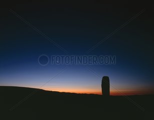 Moon rising on a menhir in Lozere Mount Cévennes France