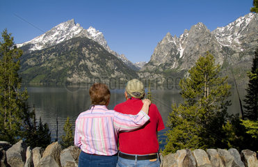 Retired senior couple relaxing at lake and enjoying the beautiful Grand Tetons mountain range near Jackson Wyoming in National Park USA