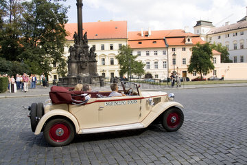 Old fashioned classic sightseeing auto in front of Archbishop Palace of tourist city of Prague in Czech Republic