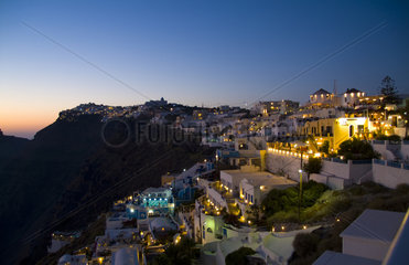 Santorini Greece and the beautiful white buildings on the mountain cliffs of main city of Fira at night