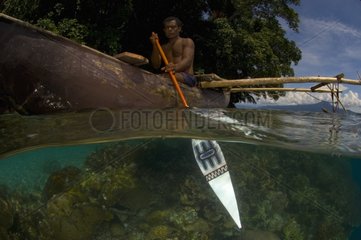Man paddeling outrigger and reef - PNG