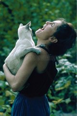 Woman laughing with the glares and carrying a cat in her arms