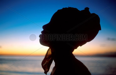 A Macoa girl named Fato stands as a living sculpture against the sub-tropic evening sky. Nampula. Ilha de Mozambique