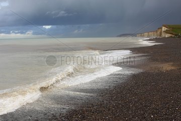 Stormy sky and rough sea on shingle beach Normandy France