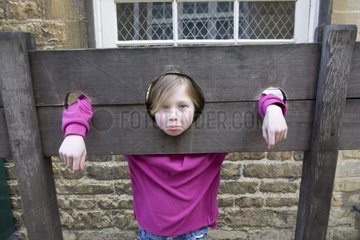Junges Mädchen in Holz mittelalterlicher Aktien Bourton auf dem Wasser Großbritannien