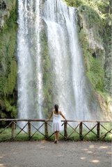 Young woman at the foot of a waterfall Spain