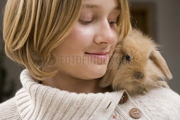 Girl with a young rabbit ram on the shoulder France