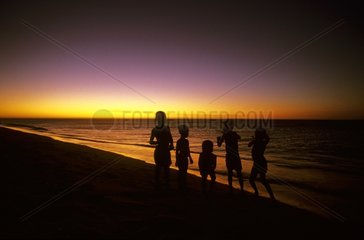 Children playing on a beach at dusk Madagascar
