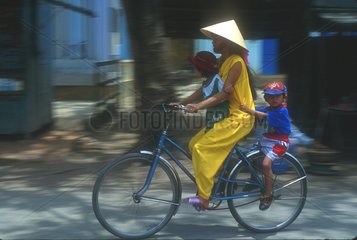Femme et ses deux enfants sur un vélo à Hoi An au Vietnam