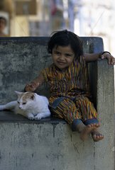 Cat lying down near a child India