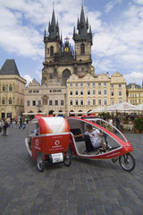 New modern bicycle taxis in the beautiful colorful architecture of the famous Old Town in Prague Czech Republic
