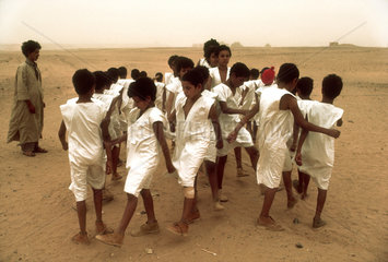 WEST SAHARA : Saharawi schoolboys marching in the desert. Near a Polisario school in the no-mans land of the border region between Algeria and the by Marocco occupied former Spanish colony of West Sahara.