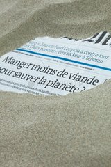 Newspaper burried into sand