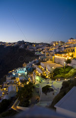 Santorini Greece and the beautiful white buildings on the mountain cliffs of main city of Fira at night