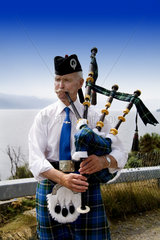 Colorful outfit and personality of bag pipe player at the Loch Ness area near Drumnadrochit home of the Loch Ness Monster Nessie in the Scotish Highland