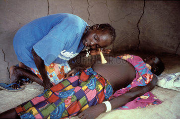 Sudan. Midwife listening to the babys heartbeat.