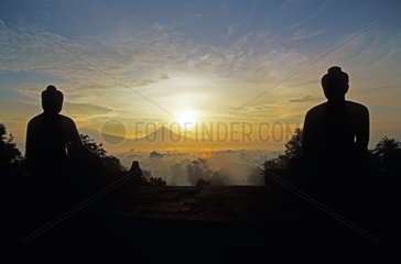 Silhouettes of statues of Buddha at sunrise Java