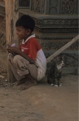 Katze sitzt mit Abmessungen eines jungen Menschen Kampuchea in Kampuchean