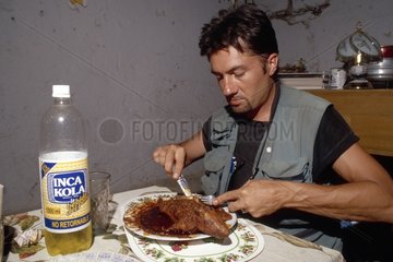 Man eating a guinea-pig cooked Peru