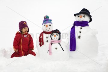Girl in the midst of a family of snowmen
