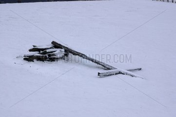 Croix tombée au sol sous la neige