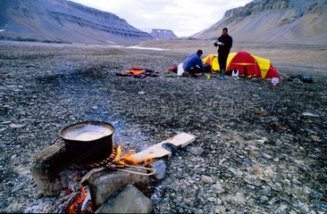 Abendessen rund um das Holzfeuer an einem Strand am arktischen Strand