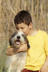 Enfant tenant dans ses bras un chien bâtard