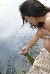 Young woman touching water by a lake Spain