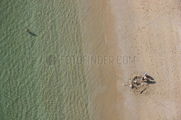 Kinder spielt an einem Sandstrand und Badin Frankreich