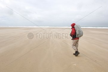 Hiker on a beach along the Manche Surtainville France
