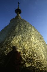 Bhikkhu praying in front of Golden Rock Kyaitiyo Burma