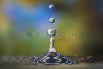 Drops of water with the reflection of the map of the Earth inside them