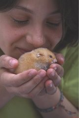 Young woman holding a domestic Hamster in her hands
