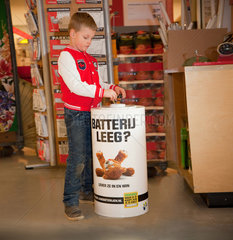 Boy throwing batteries away. Arnhem  Netherlands  Europe