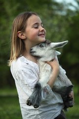 Young goat in the arms of a little girl - Tuscany