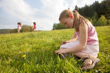 Girl sitting in a meadow in spring - Alsace France