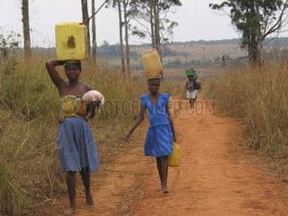 Women carry water on their heads. Feeding centres and other humanitarian aid were organised in Angola after widescale malnutrition during and following the countrys civil war.