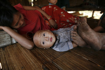 A woman lies down next to her baby in La Per Her. In Myanmar (Burma)  thousands of people have settled near the border as a result of oppression in their homeland. Around 200 Burmese displaced people have settled in La Per Her  a village on the Burmese si