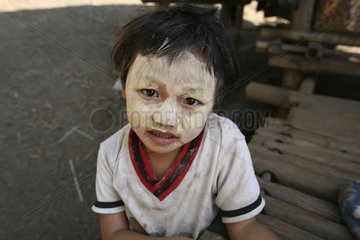 A Burmese child with decorative face painting in the camp on the border with Thailand. In Myanmar (Burma)  thousands of people have settled near the border as a result of oppression in their homeland. Around 200 Burmese displaced people have settled in La