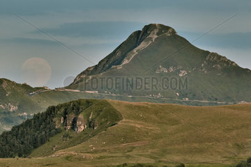 Full moon sunrise near Puy Mary (1783 m) in summer  Monts du Cantal  Auvergne Volcanoes Regional Nature Park  France