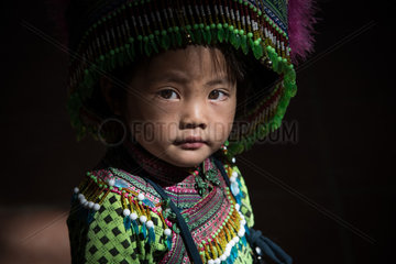 Vietnamese girl at Sapa covered market in Northern mountains. She is dressed in the traditional clothes of Hmong flowers.