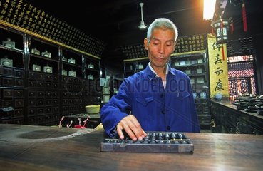 Pharmacist calculating with his abacus Huanzhu China