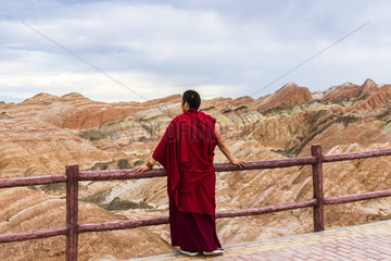 Monk and Eroded hills of sedimentary conglomerate and sandstone  Unesco World Heritage  Zhangye  China