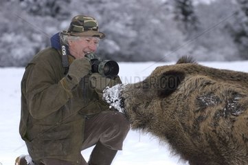 Europäischer Fotograf und Wildschwein im Schnee Frankreich