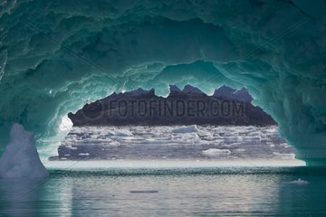 Arch of ice at the base of a Greenland Iceberg Aappilattoq