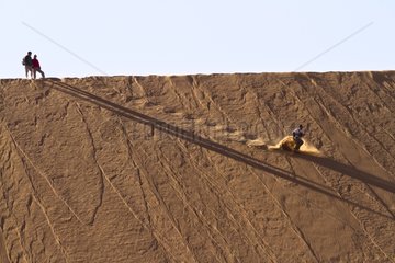 Adventurer dashing down a dune at Deadvlei Namibia