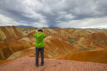 Tourist photograph  Eroded hills of sedimentary conglomerate and sandstone  Unesco World Heritage  Zhangye  China
