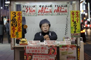 Woman selling lottery tickets in Tokyo Japan