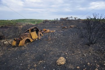 Wrecked car in scrubland fire - France